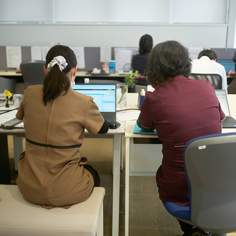 デスクで作業する随行看護師